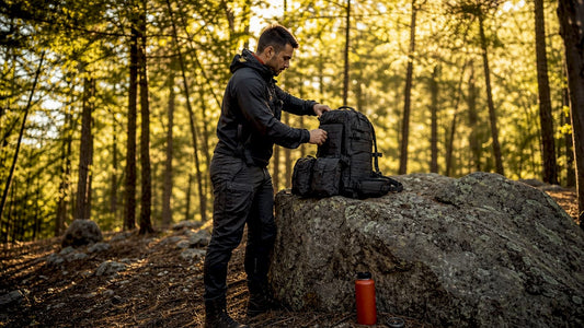 Man adjusting tactical pack attachment points outdoors