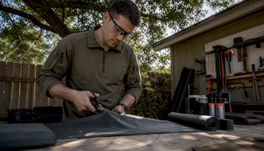Technician cutting weatherproof tactical fabric at workbench